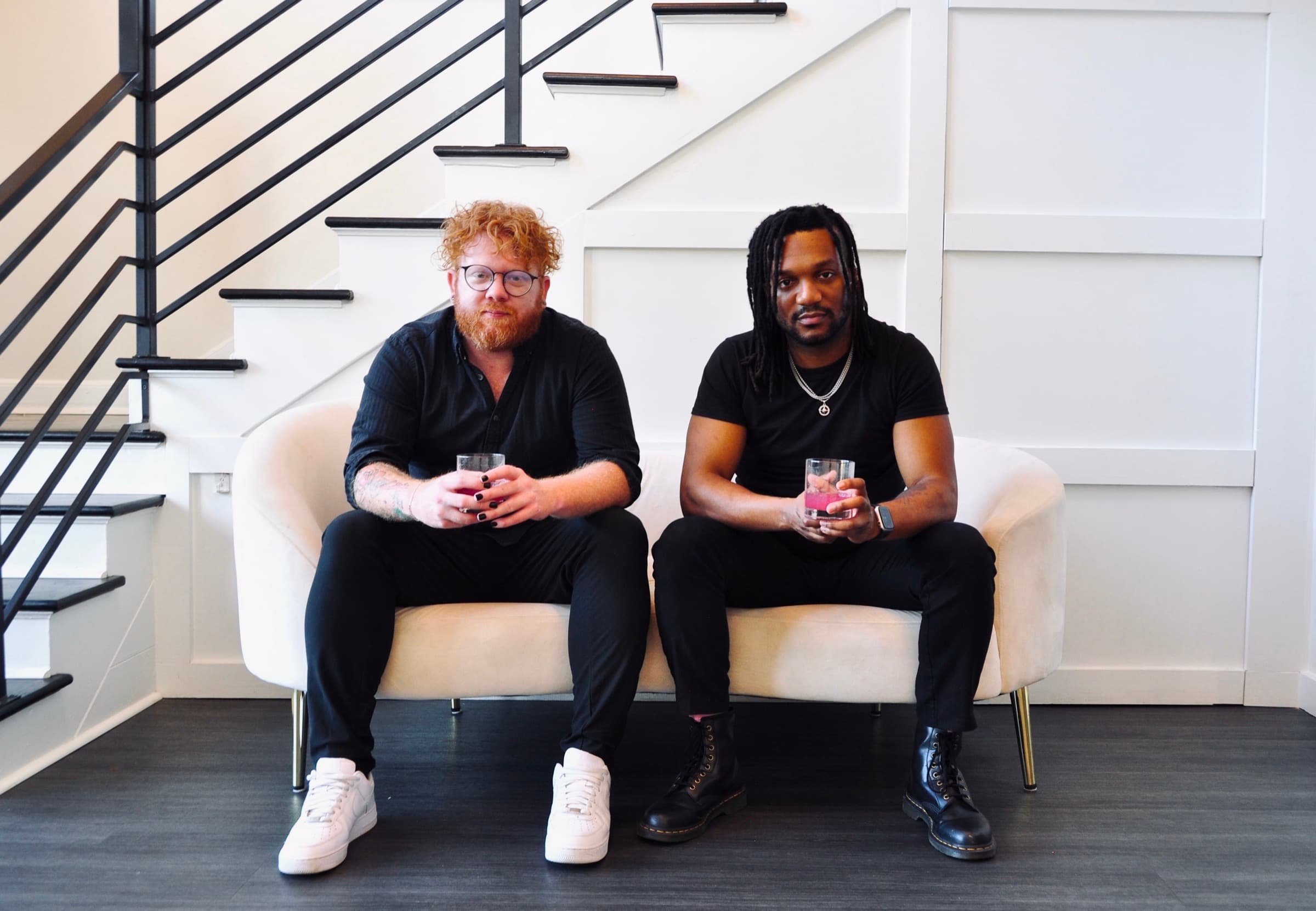 The two bartenders behind The Sober Bartender holding signature berry drinks